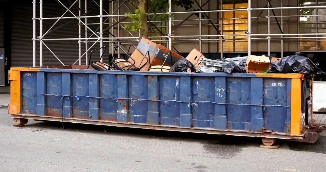 20 yd dumpster roll-off container filled with mixed debris on a city street