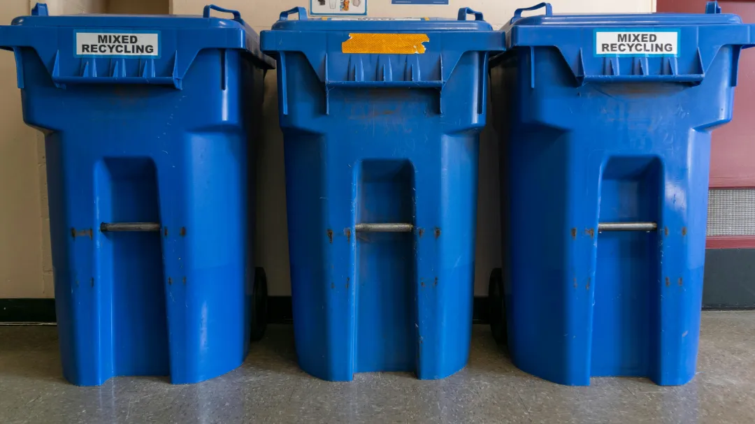 Two blue garbage containers standing next to each other Description : Two containers standing side by side. Footprint is the specification households underestimate: a second body doubles the width a storage space has to give up, which is the trade a divided double bin unit avoids by splitting one footprint between two streams.
