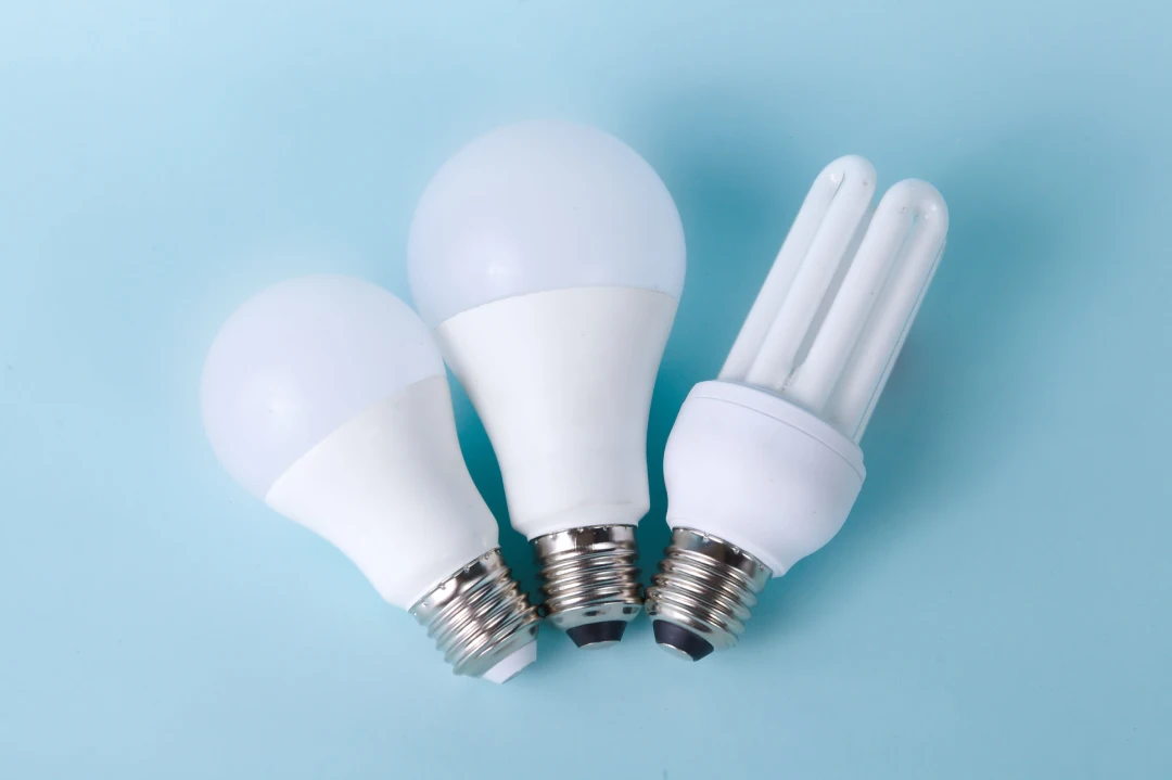 A 2U compact fluorescent lamp beside two LED bulbs, the mercury line that decides recycling tube fluorescents and CFLs